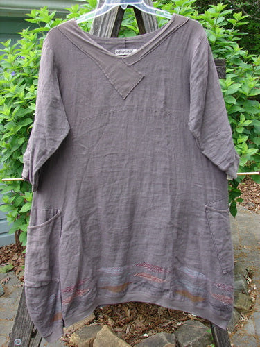 The Barclay Linen Crossover Urchin Dress features a V neckline, drop shoulders, empire waist, varied side lengths, and feather border, embodying Bluefishfinder.com's vintage, creative style.