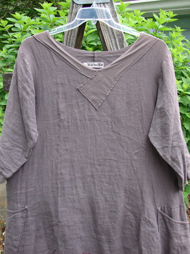 Barclay Linen Crossover Urchin Dress Feather Border Pebble Size 0, featuring a V-neckline, drop shoulders, empire waist, varying side lengths, flutter hemline, and double side pockets, embodying vintage Blue Fish individuality.