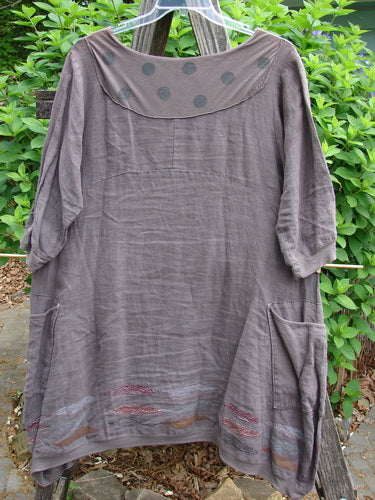 Barclay Linen Crossover Urchin Dress Feather Border Pebble Size 0 features a crossover V-neck, drop shoulders, curved empire waist, asymmetrical hem, flutter hemline, and double side pockets, embodying vintage elegance.