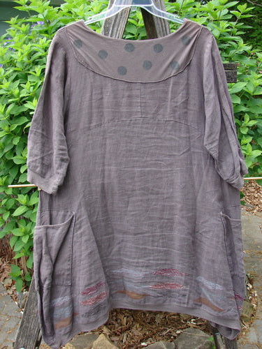 Barclay Linen Crossover Urchin Dress Feather Border Pebble Size 0 features a crossover V-neck, drop shoulders, curved empire waist, asymmetrical hem, flutter hemline, and double side pockets, embodying vintage elegance.