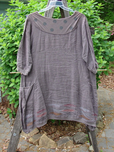 Barclay Linen Crossover Urchin Dress Feather Border Pebble Size 0, featuring a crossover V-neck, drop shoulders, and a curved empire waist, with flutter hemline and double pockets, ideal for summer wear.