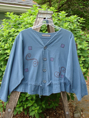 The 1997 Treehouse Jacket Path Less Traveled Blueprint Size 2 showcases a double-paneled V-neck, unique hemline, and draw cord flounce. Features Blue Fish buttons and signature back patch.