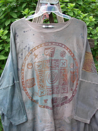 Barclay NWT Patched Supima Taos Mountain Tunic, featuring intricate patchwork, drapes elegantly on a swinger. The tunic embodies BlueFishFinder's creative spirit, offering a unique, comfortable fit for diverse body types.