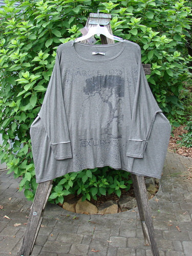 Barclay NWT Rayon Spandex Mariposa Square Top 1923 in Tree Grey OSFA displayed on a wooden rack, showcasing its drape and fabric texture, emphasizing its versatility and individuality.