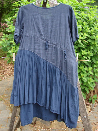 The Barclay Cross Over Two Tier Angle Dress features a layered, prairie-inspired design with oversized side pocket and laced hemline, embodying vintage elegance from Bluefishfinder.com.