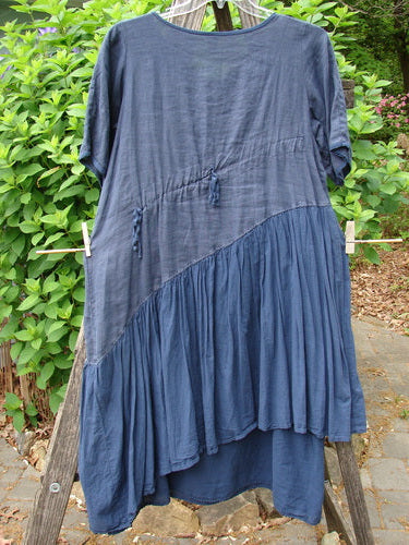 The Barclay Cross Over Two Tier Angle Dress features a layered, prairie-inspired design with oversized side pocket and laced hemline, embodying vintage elegance from Bluefishfinder.com.