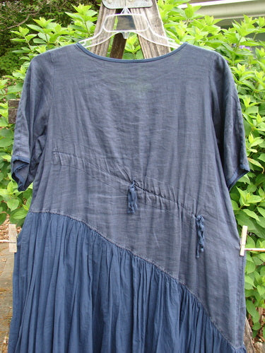 Barclay Cross Over Two Tier Angle Dress features a layered prairie style with diagonals, oversized side pocket, and laced hemline, embodying romantic summer charm in lightweight linen.