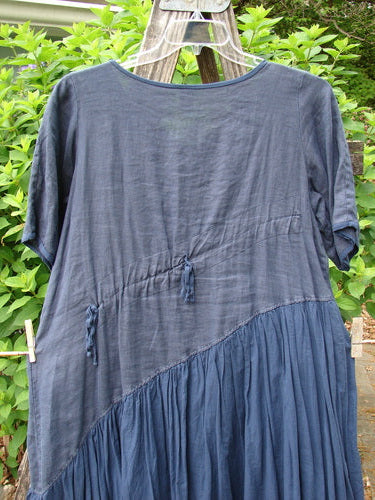 Barclay Cross Over Two Tier Angle Dress features a layered prairie style with diagonals, oversized side pocket, and laced hemline, embodying romantic summer charm in lightweight linen.