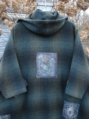 1995 Patched Hooded Autumn Jacket in Cottage Green Plaid. A coat with a patch on it, featuring oversized vintage buttons, a cozy double-lined hood, and deep side pockets. A true winter treasure!