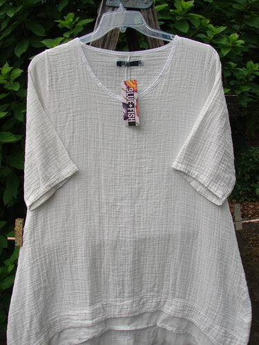 Barclay NWT Gauze Hi Low Batiste Flutter Dress Unpainted Jasmine Dew Size 0, showcased on a clothes rack, highlighting its elegant flutter sleeve and unique hi-low hem design.