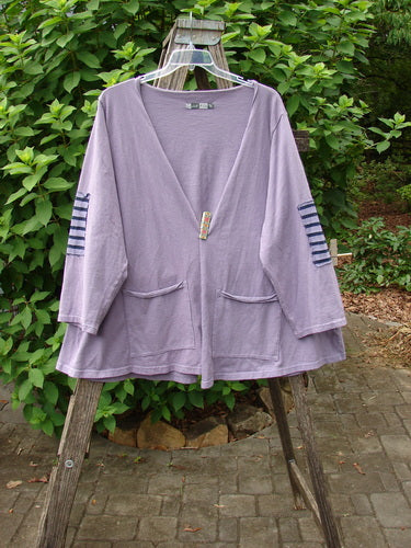 Barclay Sample Open Front Stripe Patch Jacket Rear Celestial Lavender OSFA displayed on a clothes rack outdoors, showcasing its unique open front design and patchwork detailing, embodying Bluefishfinder.com's vintage, expressive style.