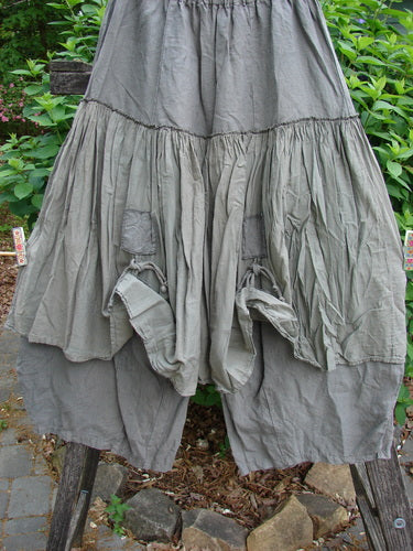 Barclay Linen Batiste Pant Skirt in Grey Green, featuring a full elastic waist, triangular patches with dual ties, and a layered design with tapered sectional panels, embodying Blue Fish's creative freedom.