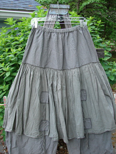 Barclay Linen Batiste Pant Skirt Unpainted Grey Green Size 0 features an elastic waistband, triangular patches, and a double-tie overpiece, showcasing a layered design with tapered pant lowers.