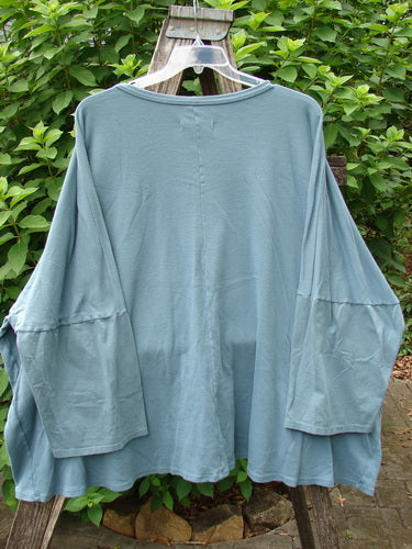 Barclay Two Pocket Mariposa Pullover Blue Sea OSFA showcased on a swing, highlighting its relaxed fit and unique design, embodying the creative and individualistic spirit of BlueFishFinder.com.