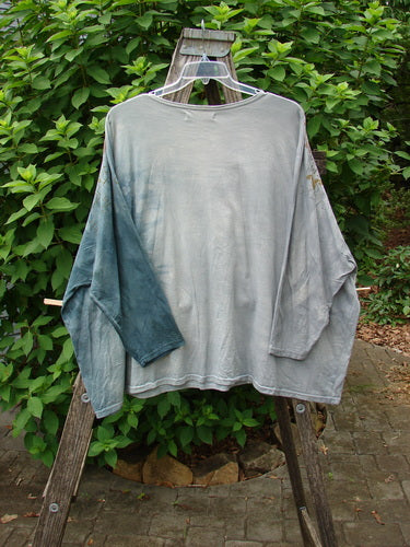 Barclay Dolman Sleeved Big Square Tunic Primitive Path Mottled Teal Gray OSFA displayed on a swinger, showcasing its relaxed fit and unique design, emblematic of BlueFishFinder's vintage style.
