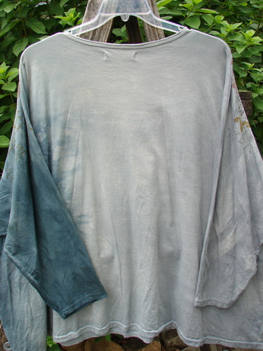 Barclay Dolman Sleeved Big Square Tunic Primitive Path Mottled Teal Gray OSFA displayed on a clothes rack, showcasing its unique dolman sleeves and oversized fit, typical of Blue Fish Clothing's vintage-inspired style.