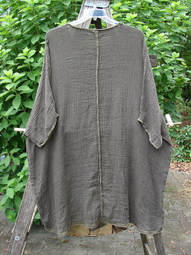 Barclay Gauze Linen Exterior Curve Hi Low Pullover features a stylish drape on a clothes rack, showcasing its unique, flowing silhouette that aligns with BlueFishFinder's vintage clothing ethos.