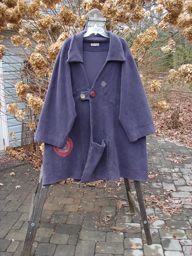 Barclay Celtic Moss Patched Highlander Coat Celtic Floral Deep Violet Size 1 on a rack, showcasing its oversized vintage buttons, deep collar, and unique diagonal seams with a large front pocket.