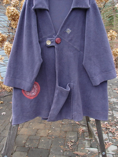 Barclay Celtic Moss Patched Highlander Coat: A purple coat with buttons, featuring serious seams set on the diagonal. Oversized vintage front buttons, a deep collar neckline, and significant patches throughout.