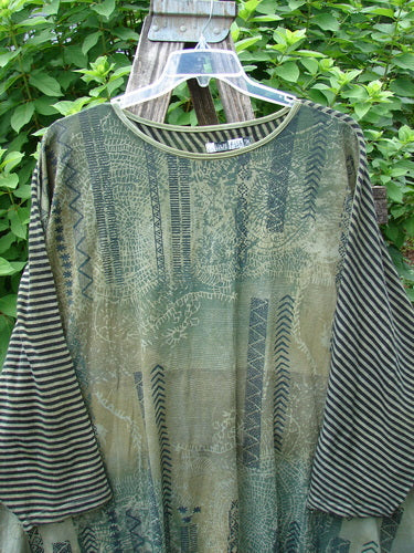 Barclay Modernist High Low Top Continuous Path Black Green Stripe OSFA: A close-up of a striped long-sleeved shirt on a hanger, showcasing its unique high-low hem design.