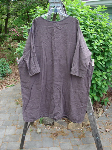 Barclay Linen Oversized Gallery Dress Shop Dress Stick OSFA features a rounded neckline, drop shoulders, and three-quarter dolman sleeves. It has a wide, straight, pocketless design, emphasizing artistic expression.