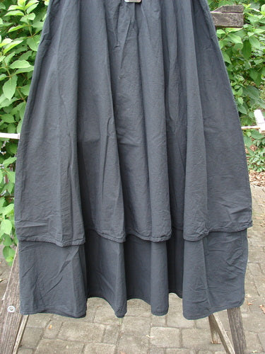 Barclay NWT Batiste Fold Over Stardust Two Tier Skirt Unpainted Black Raven Size 0 displayed on a rack, showcasing its elegant two-tier design and unique fold-over detail, epitomizing BlueFishFinder's vintage creative fashion ethos.