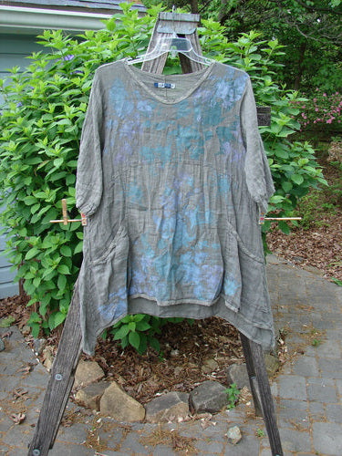 Barclay Linen Two Pocket Urchin Dress Mixed Garden Grey Moss Size 0, features an empire waist, rounded neckline, A-line flair, swaying hem, wider sleeves, and exterior drop front pockets.