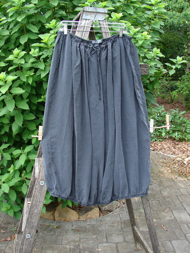 Barclay Silk Drawstring Bell Skirt Unpainted Raven OSFA displayed elegantly on a wooden ladder, showcasing its flowing silhouette, crafted for creative expression and individuality.