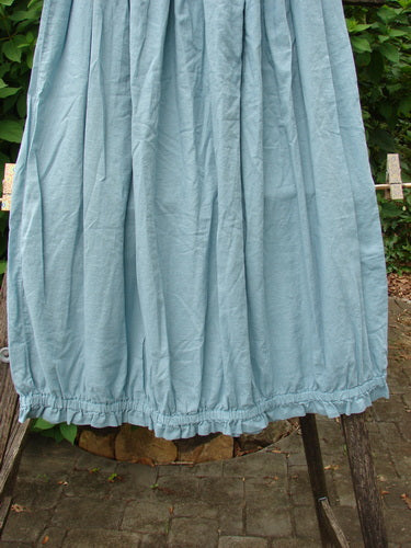 Barclay NWT Batiste Airy Gather Bottom Skirt features an unpainted turquoise pinstripe design, elegantly draped on a clothes rack. Ideal for expressing individuality, this vintage Blue Fish Clothing piece is size 0.
