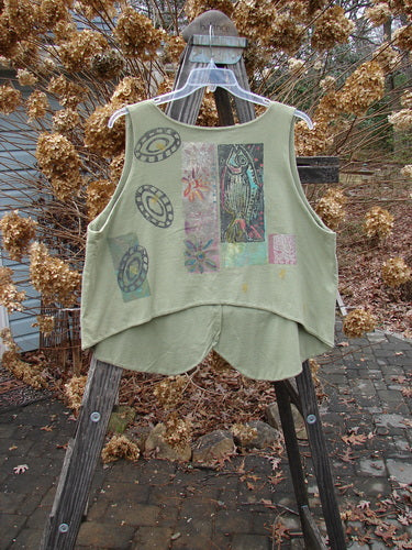 1989 Folk Vest Fish Flower Star Sage OSFA displayed on a hanger, showcasing its front tuxedo tails, matching buttons, V-shaped neckline, upward scooped backline, and vibrant floral star patterns.