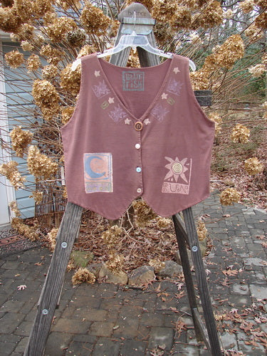 1989 Folk Vest Sun Moon Paprika OSFA hanging on a rack, featuring unique buttons, front tuxedo tails, a scooped back, and colorful vintage sun and moon designs on heavy cotton.