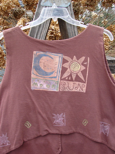 1989 Folk Vest Sun Moon Paprika OSFA featuring vibrant sun and moon painting, mix-and-match buttons, and tuxedo tails. This vintage piece offers an upward scooped back and V-shaped neckline.