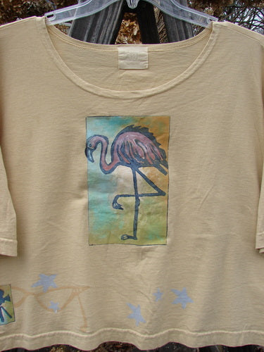2000 Short Sleeved Crop Tee Flamingo Plantain Size 2, featuring a playful flamingo print, softly rolled neckline, wide swingy lower shape, and Blue Fish Patch 2k Patch, made from organic cotton.