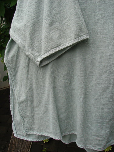Barclay Gauze Round Bottom Tie Back Pocket Top Unpainted Grass Size 2, shown close-up, features a textured, loosely woven fabric with visible sleeve and side seam, reflecting BlueFishFinder's vintage, creative style.
