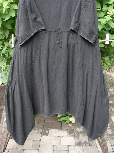 Barclay Gauze Urchin Bell Dress Unpainted Black Size 1 hangs on a clothesline, showcasing its loose fit, uneven drapey hem, and drawstring waist, reflecting Bluefishfinder.com's vintage, creative style.