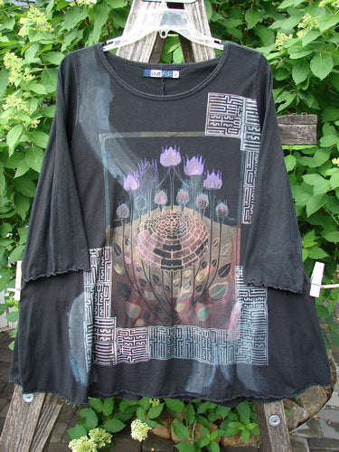 Barclay Three Quarter Sleeved Cafe Tee Floral Bloom Black Size 0, hangs on a ladder, featuring stylized purple lotus flowers within a maze-like design, square labyrinth-patterned corners, and a rounded neckline.