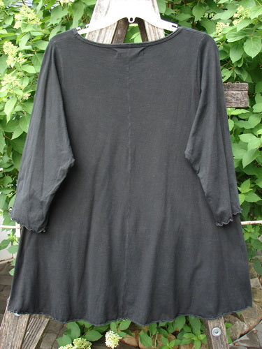 Barclay Three Quarter Sleeved Cafe Tee Floral Bloom Black Size 0, displayed outdoors on a wooden ladder, features a loose, A-line shape with sweet curly edgings, showcasing timeless elegance from Bluefishfinder.com.