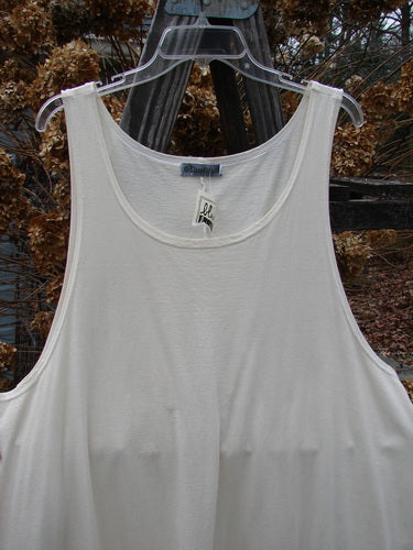 Barclay NWT Long Simple Smock in creme on a clear plastic hanger, showcasing its A-line shape, deep rounded neckline, and seamless front. Organic cotton smock from Bluefishfinder's vintage collection.