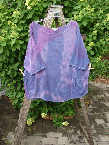 Barclay Gauze Round Bottom Tie Back Pocket Top Mottled Purple Dusk Size 2, featuring an oversized, short-sleeved design with two patch pockets, hangs on a wooden ladder, capturing the essence of Bluefishfinder's vintage style.