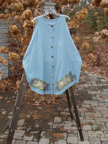 1994 Sleeveless Vest Starfish Ice Size 1: A blue dress and shirt on a clothes rack, featuring a shallow neckline and deep arm openings. Vintage buttons and a fish-themed paint design. Bust 62, waist 62, hips 62. Lengths: front 35, back 35, sides 32.