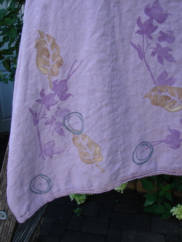 Barclay Linen Lace Blooming Tunic Dress, Leaf Vine Lavender Size 0, displayed outdoors, showcases a crossover neckline, empire waist, lace-trimmed hem, with botanical motifs, embodying Bluefishfinder's unique vintage style.