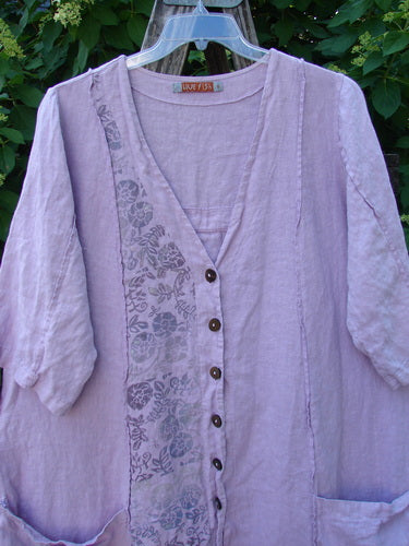 Barclay Linen Double Tie Back Jacket in Pink Cloud features a V-neck, dark buttons, floral panel, ¾ sleeves, patch pockets, and a varied hemline, embodying BlueFishFinder's unique vintage style.