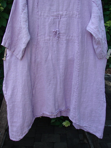 Barclay Linen Double Tie Back Jacket Single Garden Row Pink Cloud Size 1 features a loose, long-sleeved tunic with a deep V-neckline and A-line sweep, hanging outdoors.