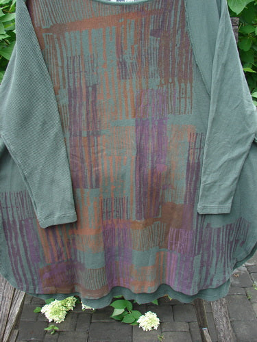 Barclay Thermal Monte Verde Vented Tunic Linear Blend Army OSFA, featuring a waffle-knit green sleeve and striped body, hangs outdoors, highlighting its unique blend of textures and contrasting stitch details.