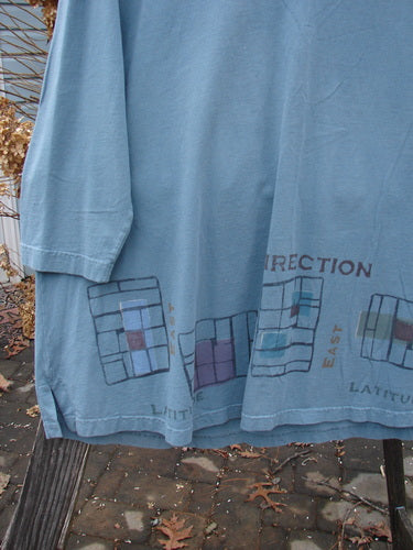 2000 V Neck Grid Top Direction Travel Puddle Size 1 features an organic cotton grid pattern with a V neckline, single cuff, A-line shape, vented sides, rounded bottom sweep, and blue fish patch.