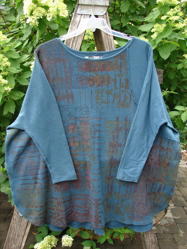 Barclay Thermal Monte Verde Vented Tunic Grid Blend Tealen OSFA displayed on a wooden ladder, featuring a teal shade with a rusty brown and deep blue abstract pattern, rounded neckline, and side vents.