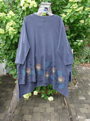 Barclay Single Button Painter's Jacket Moon Flower Deep Navy Size 3 on a wooden ladder, showcasing its asymmetrical hem, drop shoulders, oversized pocket, and moon flower theme print against a leafy background.