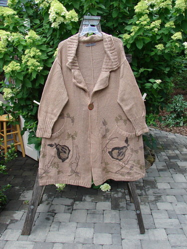 1998 Cotton Knit Canyon Cardigan Sweater Coat Pear Harvest Aspen OSFA displayed on a stepladder in a garden, featuring a ribbed shawl collar, single button, two fruit-motif pockets, and full-length sleeves.