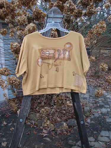 1994 Song Top Make Music Dijon Size 2 displayed on a swinger, showcasing a wide crop box shape, oversized painted front pocket, and music-themed illustrations with oversized buttons.
