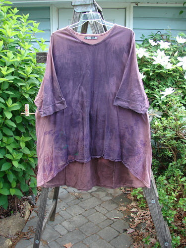 The Barclay Banded Drawcord Art Top Paisley Patch in Mottled Plum features a tunic length with drop shoulders, loose three-quarter sleeves, and a rounded neckline, showcasing its unique tiny village paisley design.